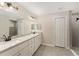 Bright bathroom features double sinks with granite counters, sleek white cabinets, and a tiled walk-in shower at 114 Bay Dr, Ocklawaha, FL 32179