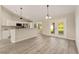 Open floor plan featuring stainless steel appliances, white cabinets and granite counters, and adjacent dining area at 114 Bay Dr, Ocklawaha, FL 32179