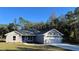 Charming single-story home featuring a gray exterior, a well-manicured lawn, and an attached two-car garage at 114 Bay Dr, Ocklawaha, FL 32179