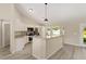 Bright kitchen with white cabinets, granite countertops, stainless steel appliances and a breakfast bar overlooking the living area at 114 Bay Dr, Ocklawaha, FL 32179