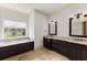 Bathroom featuring a soaking tub, granite countertops, dual sinks and dark wood cabinetry at 12424 Sw 140Th Loop, Dunnellon, FL 34432
