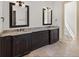 Bathroom with dual sinks, granite countertops, dark wood cabinets, and neutral tile floors at 12424 Sw 140Th Loop, Dunnellon, FL 34432