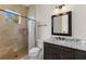 Bathroom with tiled shower, granite vanity, tile floors, and a framed mirror at 12424 Sw 140Th Loop, Dunnellon, FL 34432