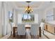 Bright dining room featuring a modern chandelier, large windows with views, and seating for six at 12424 Sw 140Th Loop, Dunnellon, FL 34432