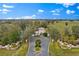 Aerial view of a gated entrance with mature trees and landscaping leading into a private estate at 12424 Sw 140Th Loop, Dunnellon, FL 34432