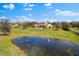 Picturesque view of a grand estate with a large pond, fountain, and manicured grounds on a sunny day at 12424 Sw 140Th Loop, Dunnellon, FL 34432