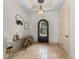 Elegant foyer features tile flooring, decorative mirror, a glass table, and ornate door at 12424 Sw 140Th Loop, Dunnellon, FL 34432