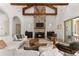 Spacious living room featuring a stone fireplace, wood beams, and comfortable seating at 12424 Sw 140Th Loop, Dunnellon, FL 34432