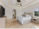 Spacious main bedroom with tiled floors, tray ceiling, neutral decor, and a large window at 12424 Sw 140Th Loop, Dunnellon, FL 34432