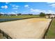 Aerial view of expansive horse riding arena with wood fence, surrounded by large, verdant pastures at 12424 Sw 140Th Loop, Dunnellon, FL 34432
