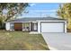 Stylish one-story house showcases a fresh exterior paint job, a two-car garage, and updated landscaping at 13384 Sw 105 Pl, Dunnellon, FL 34432