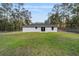 Large backyard with a view of the home's rear facade, enhanced by the natural beauty of the surrounding trees at 13396 Sw 105 Pl, Dunnellon, FL 34432