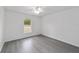 This bedroom features a ceiling fan, light gray floors, and a view of the outside at 13495 Sw 114Th Ln, Dunnellon, FL 34432