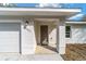 Inviting front entrance featuring a columned porch and a modern exterior light fixture at 13495 Sw 114Th Ln, Dunnellon, FL 34432