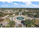An aerial view of a meticulously planned community showcasing lush landscaping and a central fountain at 13751 Se 88Th Ct, Summerfield, FL 34491