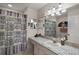 Bathroom features a granite countertop, decorative shower curtain, and a stylish light fixture at 13751 Se 88Th Ct, Summerfield, FL 34491