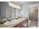 Bright bathroom with a double sink vanity, granite countertop, and a beautifully tiled walk-in shower at 13751 Se 88Th Ct, Summerfield, FL 34491