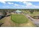 Aerial view of a golf course with a putting green and golf carts at 13751 Se 88Th Ct, Summerfield, FL 34491