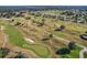 Scenic aerial view of a lush golf course with trees and sand traps at 13751 Se 88Th Ct, Summerfield, FL 34491