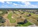 Scenic aerial view of a picturesque golf course surrounded by lush greenery and blue skies at 13751 Se 88Th Ct, Summerfield, FL 34491