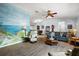 Comfortable living room with hardwood floors, a decorative mural, and an open-concept design at 13751 Se 88Th Ct, Summerfield, FL 34491