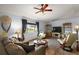 Cozy living room with hardwood floors, large windows, and comfortable seating at 13751 Se 88Th Ct, Summerfield, FL 34491