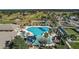 Aerial view of a resort-style pool, lounge chairs, palm trees and landscaping near the golf course at 13751 Se 88Th Ct, Summerfield, FL 34491