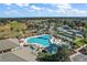 Beautiful aerial view of a community pool, sun loungers and verdant landscaping with palm trees near the golf course at 13751 Se 88Th Ct, Summerfield, FL 34491
