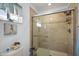 Nicely tiled walk-in shower featuring glass doors, a built-in shower caddy, and a rainfall shower head at 13751 Se 88Th Ct, Summerfield, FL 34491