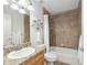 Bathroom showcasing a shower-tub combo, vanity with decorative mirror, and tile surround at 13920 Ne 38Th Ave, Anthony, FL 32617