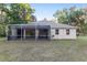 Exterior view of the house highlighting the screened lanai and spacious backyard at 13920 Ne 38Th Ave, Anthony, FL 32617