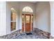 Elegant front door with glass panels, flanked by windows, and stone detailing for a refined entry at 13920 Ne 38Th Ave, Anthony, FL 32617