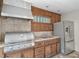 Outdoor kitchen with a stainless steel grill, refrigerator, and ample counter space, perfect for summer barbecues at 13920 Ne 38Th Ave, Anthony, FL 32617
