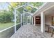 View of the patio and outdoor kitchen space from the brick-paved, screened-in lanai at 13920 Ne 38Th Ave, Anthony, FL 32617