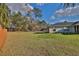 Expansive backyard featuring a lush lawn, mature trees, and partial fencing providing ample space for outdoor activities at 14 Hemlock Loop Court, Ocala, FL 34472