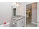 Well-lit bathroom with a granite countertop vanity, a decorative mirror, and a view into the adjacent kitchen at 14 Hemlock Loop Court, Ocala, FL 34472
