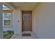 Inviting front entrance showcasing a paneled door, neutral paint, and a welcoming 'home' doormat at 14 Hemlock Loop Court, Ocala, FL 34472