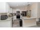 Well-appointed kitchen featuring white cabinets, granite countertops, stainless steel appliances, and an island at 14 Hemlock Loop Court, Ocala, FL 34472