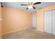 Inviting bedroom with carpet flooring, a ceiling fan, and a closet for storage and private door to bathroom at 14 Juniper Drive Crse, Ocala, FL 34480