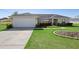 Attractive single-story home boasts a two-car garage, tidy landscaping, and a pristine lawn at 14 Juniper Drive Crse, Ocala, FL 34480