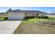 Inviting single-story home with a two-car garage, simple landscaping, and a well-manicured lawn at 14 Juniper Drive Crse, Ocala, FL 34480