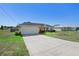 Welcoming single-story home offers a two-car garage, minimalist landscaping, and a green lawn at 14 Juniper Drive Crse, Ocala, FL 34480