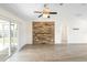 Large living room with modern ceiling fan, plank flooring, sliding glass doors, and an accent wall at 14 Juniper Drive Crse, Ocala, FL 34480