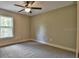 Bedroom featuring a window for natural light and neutral carpeting with a ceiling fan at 22081 Sw Pine Bluffs Rd, Dunnellon, FL 34431