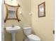 Bathroom view with sink, toilet, framed mirror, and yellow walls at 231 Ne 28Th Ave # 103, Ocala, FL 34470