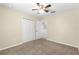 Bright bedroom featuring neutral walls, carpet floors, and a ceiling fan for added comfort at 231 Ne 28Th Ave # 103, Ocala, FL 34470