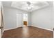 Bright bedroom features a tray ceiling, wood-look floors, and neutral paint, creating a serene space at 231 Ne 28Th Ave # 103, Ocala, FL 34470