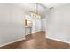 Open dining area with wood floors, a modern light fixture, and views into the kitchen at 231 Ne 28Th Ave # 103, Ocala, FL 34470