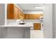 Kitchen view featuring breakfast bar and wood cabinets with white countertops and appliances at 231 Ne 28Th Ave # 103, Ocala, FL 34470