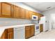 Kitchen view featuring breakfast bar and wood cabinets with white countertops and appliances at 231 Ne 28Th Ave # 103, Ocala, FL 34470